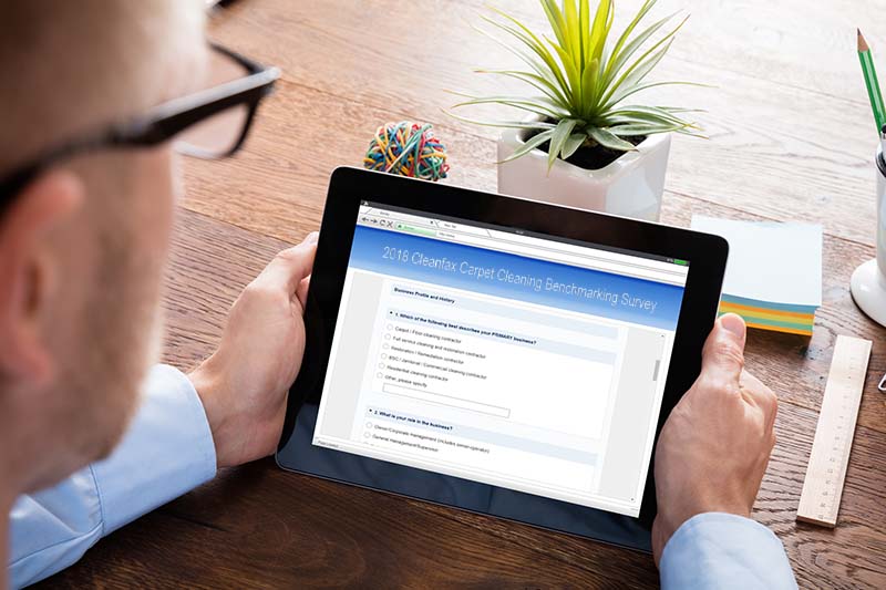 Person Filling Online Survey Form On Digital Tablet At Wooden Desk