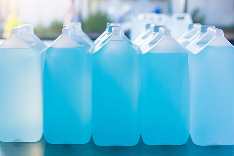 Alcohol for cleaning and sanitizing is contained in gallons in the warehouse. Many gallon alcohol gel for sanitizing Coronavirus Covid-19. Products for sale to anti Coronavirus protection (Covid 19).