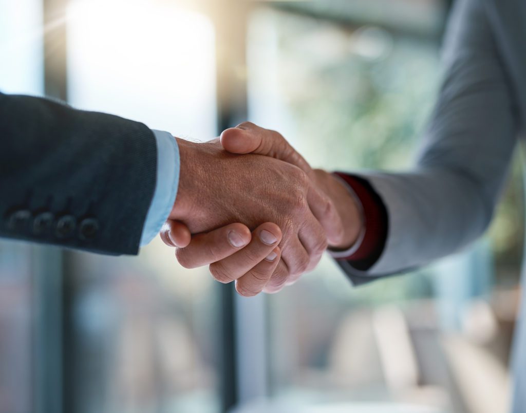 Cropped shot of two unrecognizable businessmen shaking hands after making a deal in the office
