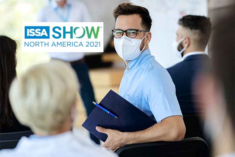 Happy businessman with protective face mask attending an educational event and looking at camera.