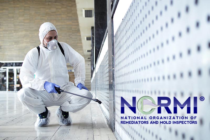 Shot of male person in white chemical protection suit doing disinfection of public areas to stop spreading highly contagious corona virus. Stop coronavirus or COVID-19.