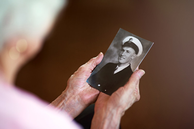 Cropped shot an elderly woman holding an old black and white photograph of a man