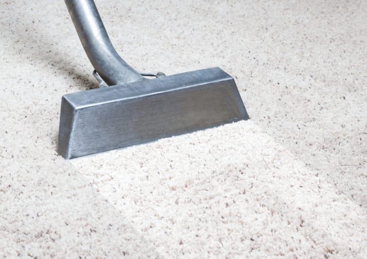 Man cleaning carpet in home