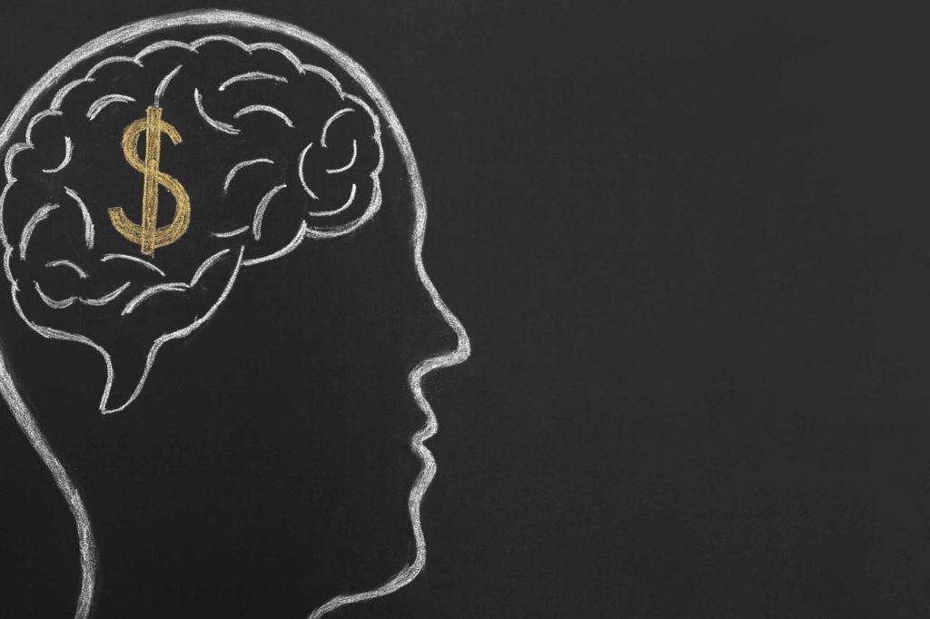 Thinking of money. Dollar sign inside brain sketched on blackboard.