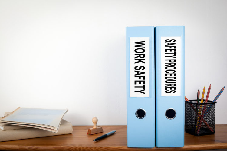 Work Safety and Safety Procedures binders in the office. Stationery on a wooden shelf