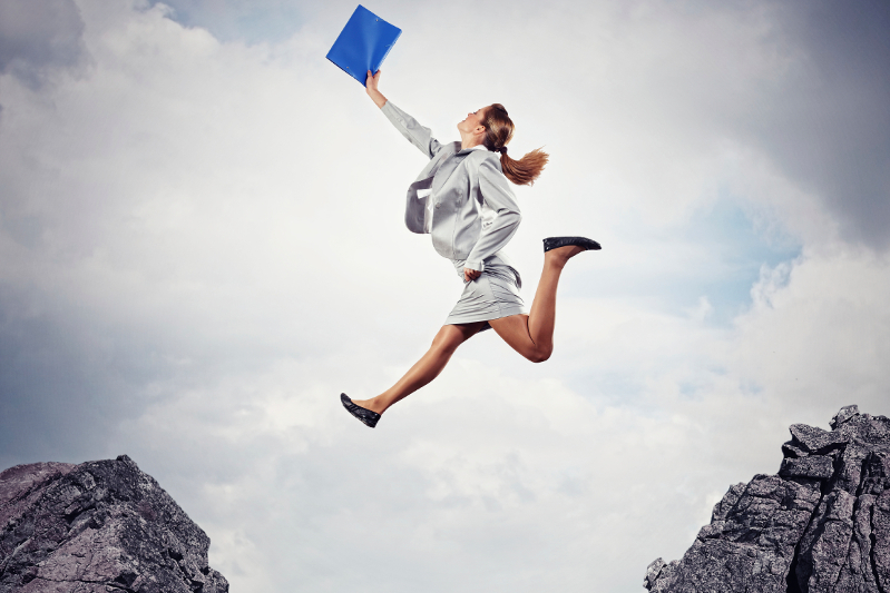 Image of young businesswoman jumping over gap