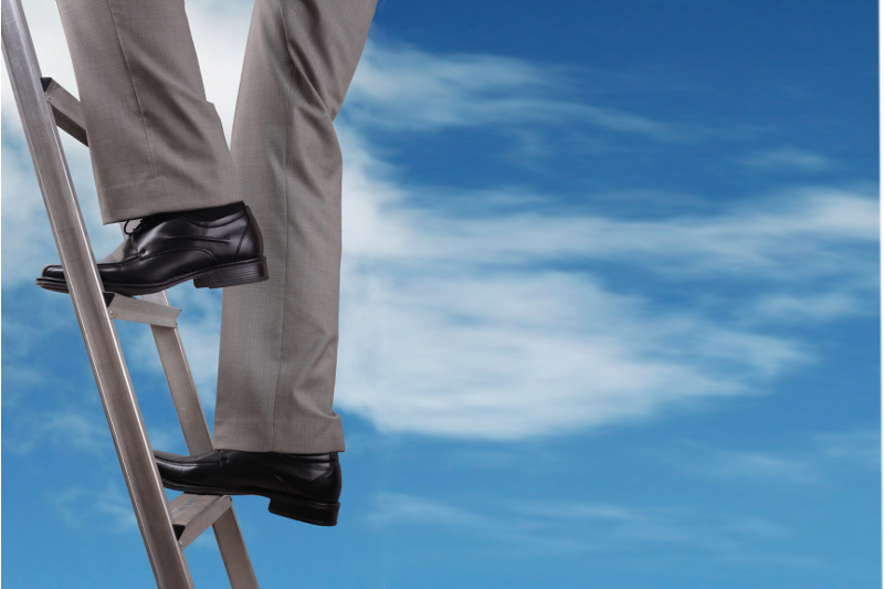 Businessman climbing the ladder of success