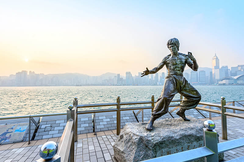 Hong Kong - February 9, 2015: Bruce Lee statue in Avenue of Stars. In the distance is Victoria Harbour. Located in the Avenue of Stars, Hong Kong.