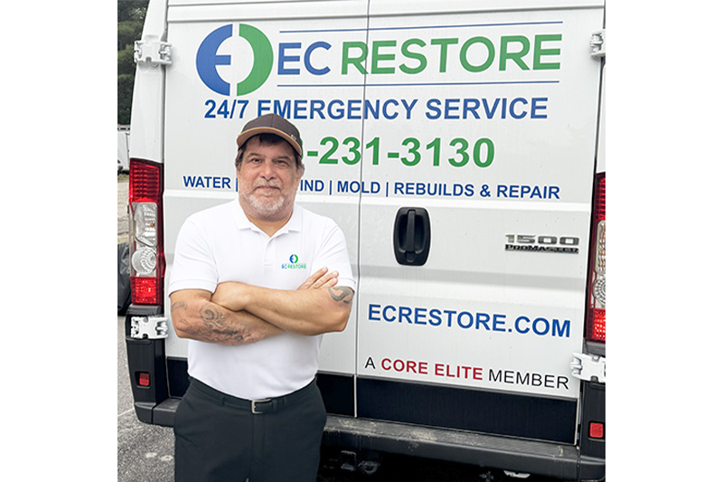 Tom Sousa standing in front of EC Restore vehicle