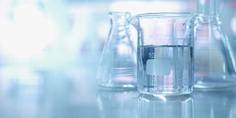 experiment water in beaker and flask in blue chemistry science laboratory background