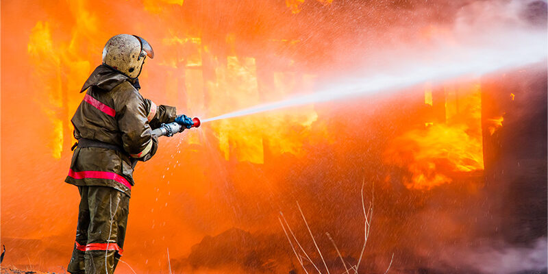 firefighter putting out a building fire