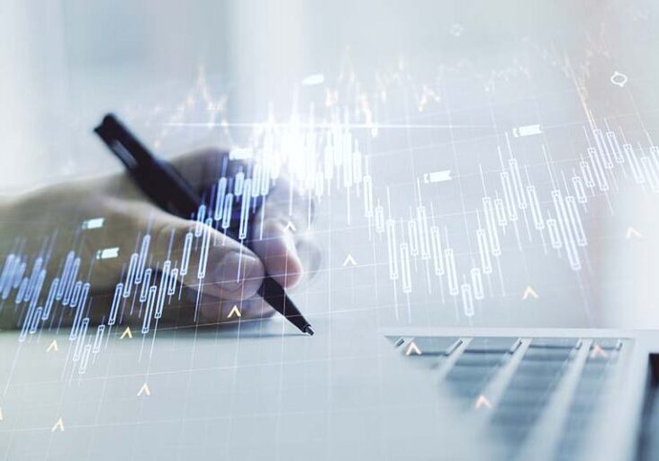 Double exposure of abstract creative financial chart with world map and with hand writing in notebook on background with laptop, research and strategy concept