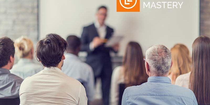 Rear view of large group of business people on a training. Focus is on foreground.