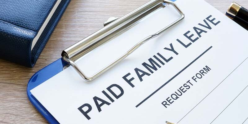 Paid family leave form in clipboard and note pad.