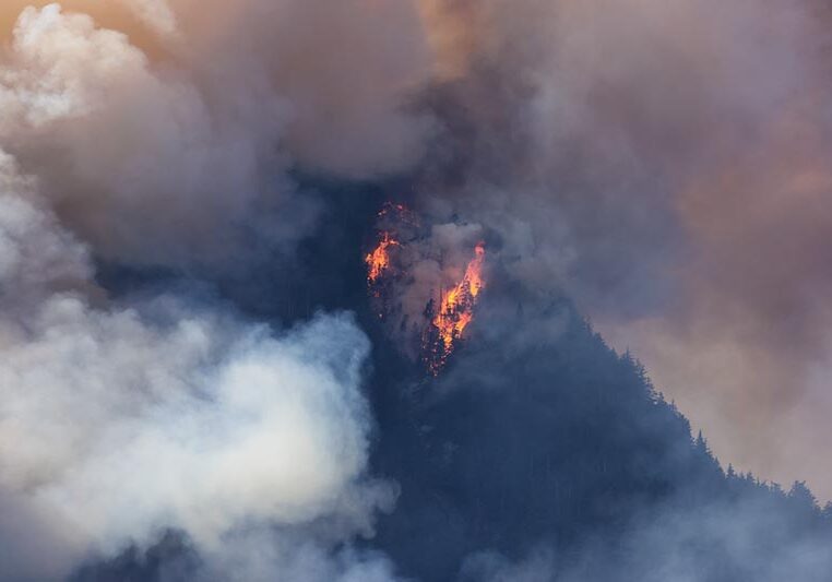 BC Forest Fire and Smoke over the mountain near Hope during a hot sunny summer day. British Columbia, Canada. Wildfire natural disaster