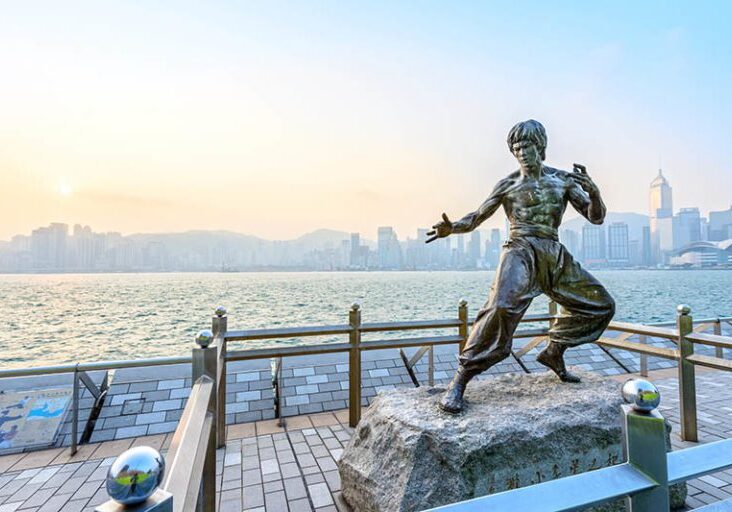 Hong Kong - February 9, 2015: Bruce Lee statue in Avenue of Stars. In the distance is Victoria Harbour. Located in the Avenue of Stars, Hong Kong.