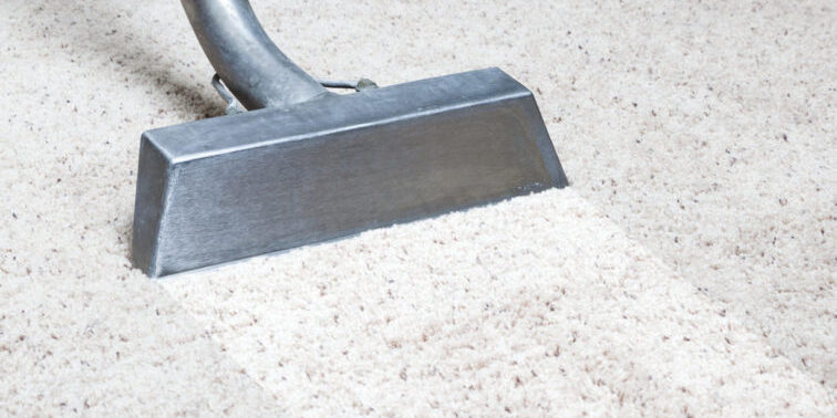 Man cleaning carpet in home