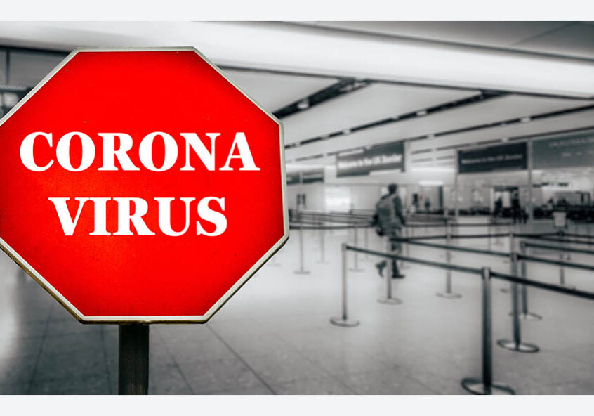 Coronavirus written on stop sign with passengers arriving at passport control within generic airport. The virus, which originated in China is quickly spreading around the world in early 2020