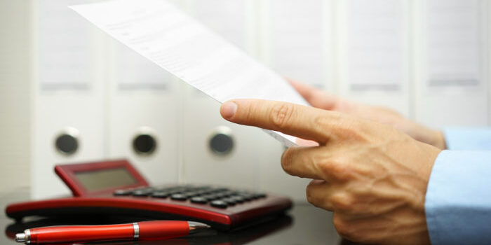 businessman is reading  and checking financial document with binders,calculator  in background