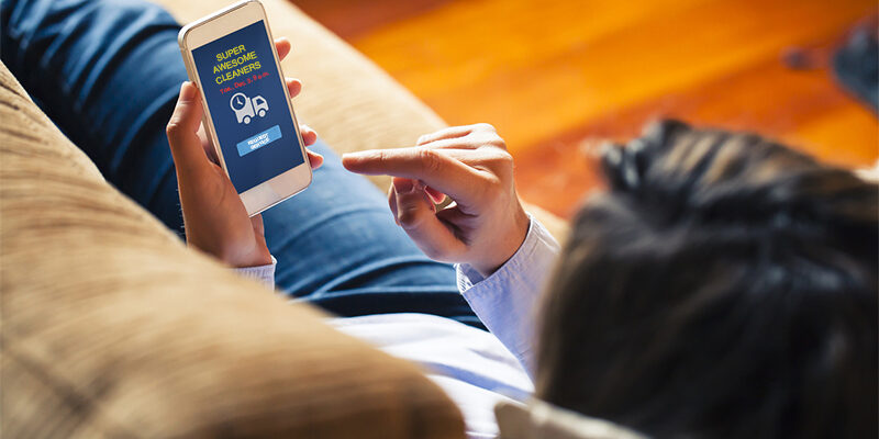 Delivery order message in a mobile screen. Woman reading it at home.