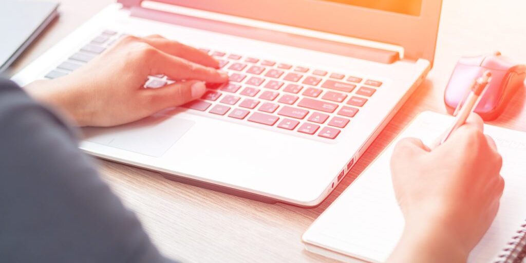 Close Up of woman hands using mobile phone and laptop computer business with blank copy space screen for your business advertising text message or content business in the morning light.