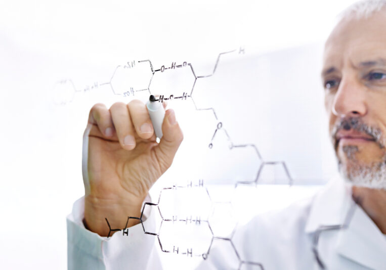 Shot of a mature male scientist drawing the structures of molecules on a glass surface