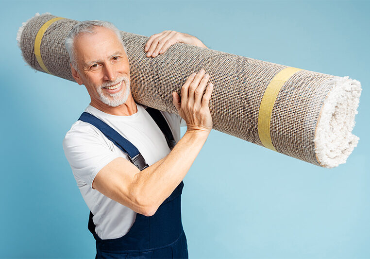 Mature male carrying carpet