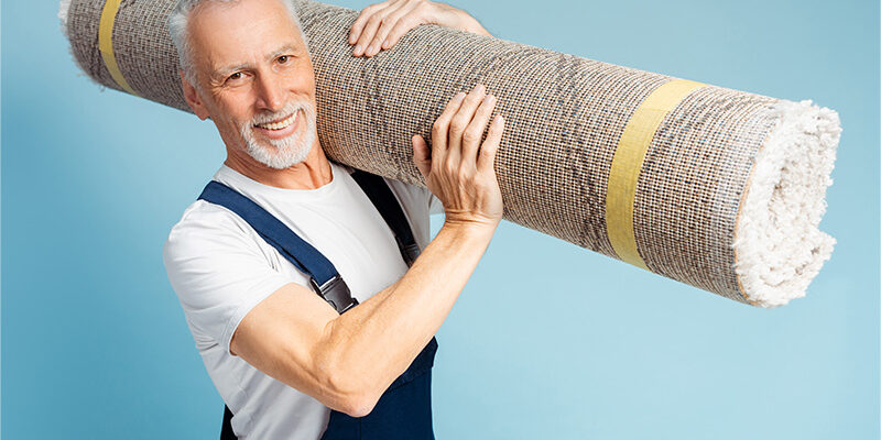 Mature male carrying carpet