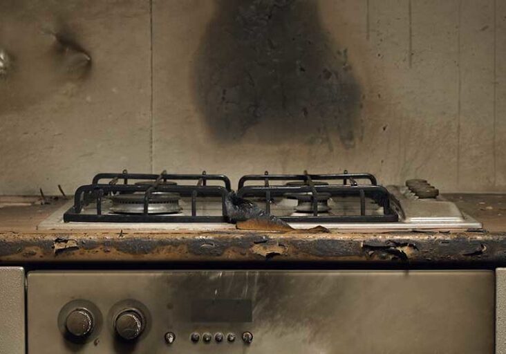 Smoke stained cooker in kitchen after fire
