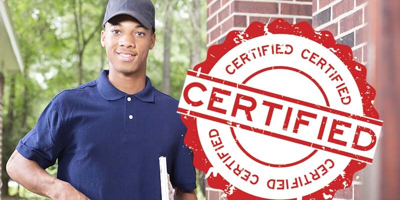 African descent repairman at customer's front door. African descent repairman or blue collar/service industry worker make service/house call at customer's front door. He holds his clipboard and tool box filled with work tools. Inspector, exterminator, electrician. Red brick home.
